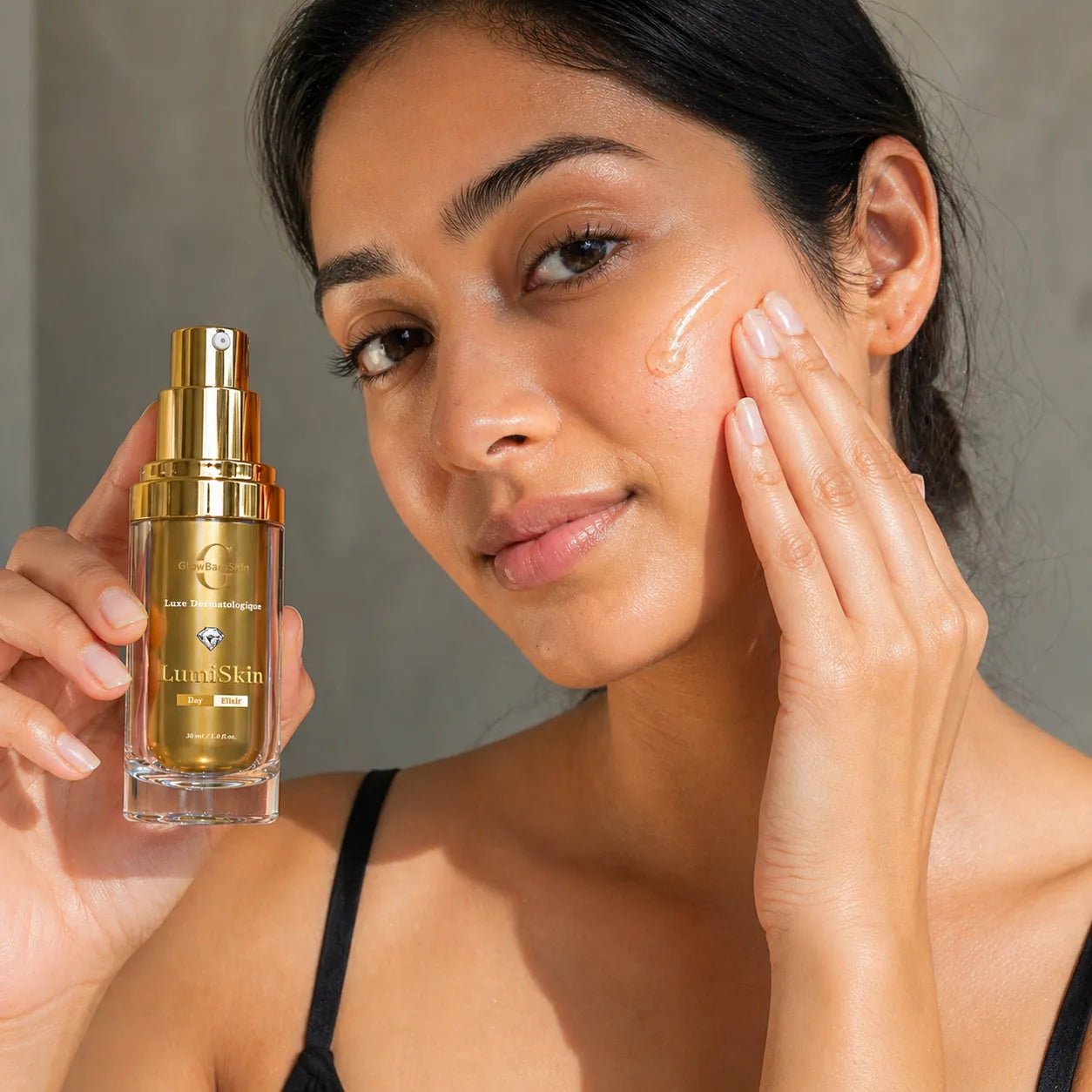Woman applying skincare product to her face with a bottle of LuminSkyn serum in front of her.